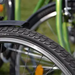 Szukasz informacji, ile kosztuje wymiana opon w rowerze? Zbliżenie na rowerowy bieżnik i obręcz.