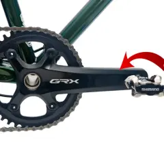Czerwona strzałka pokazuje kierunek obrotu, by dowiedzieć się, jak odkręcić pedały w rowerze. Widoczny mechanizm korbowy Shimano GRX.