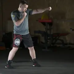 Mężczyzna ćwiczy w siłowni, wykonując ciosy. To świetny przykład, jak trening HIIT co to jest, może być efektywny.
