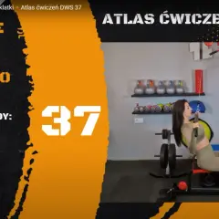 Kobieta wykonuje ćwiczenie pulldown na wyciągu górnym. Na ekranie widnieje napis "Ściąganie drążka wyciągu górnego do klatki".