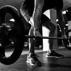 Mężczyzna wykonuje ćwiczenie rack pull, podnosząc ciężar z podłogi.