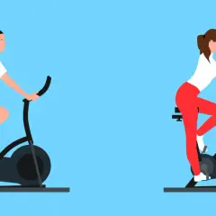 Mężczyzna i kobieta ćwiczą na rowerach stacjonarnych. To świetny sposób, by dowiedzieć się, jaki rower stacjonarny na odchudzanie wybrać.