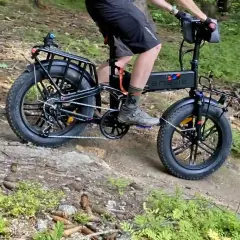 Rowerzysta na rowerze elektrycznym z grubymi oponami pokonuje leśną trasę rowerową.