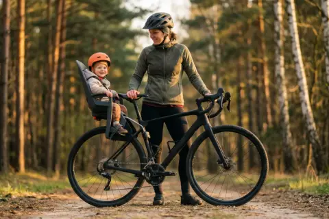 Szczęśliwe dziecko w foteliku rowerowym, gotowe na przygodę. Sprawdź nasz fotelik rowerowy ranking, by wybrać najlepszy model!