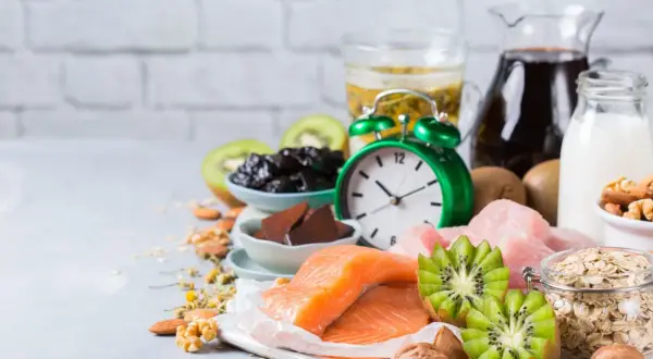 Zegar i produkty bogate w tryptofan: łosoś, kiwi, śliwki, mleko, orzechy, owies. Zastanawiasz się, po jakim czasie działa tryptofan?