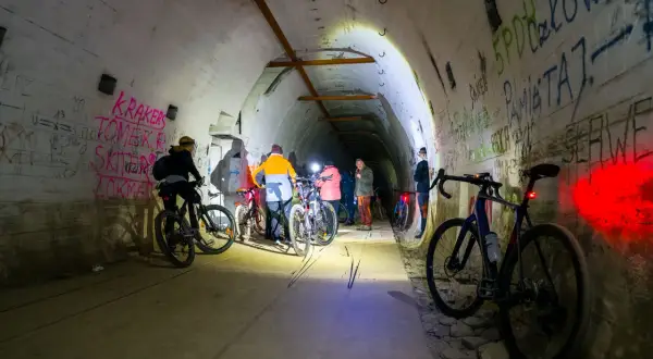 Grupa rowerzystów eksploruje mroczną, graffiti-pokrytą podziemną trasę rowerową.