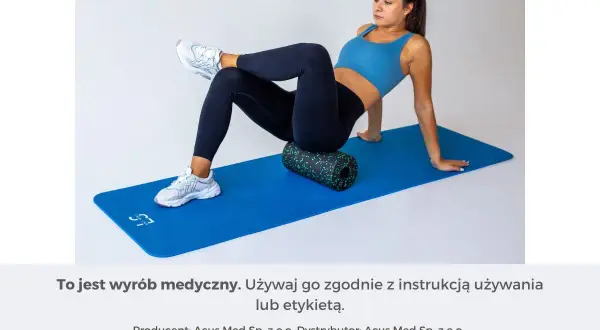 Kobieta na macie rehabilitacyjnej roluje mięsień piramidowy za pomocą wałka.