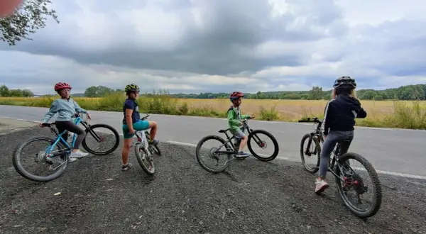Cztery dzieci na rowerach, zastanawiają się, jaki rower dla 8 latka 20 czy 24 cali będzie najlepszy.