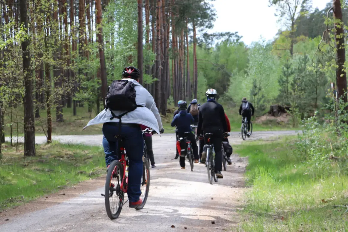 Grupa rowerzystów przemierza leśną ścieżkę. Czy jazda na rowerze odchudza? Aktywność fizyczna na świeżym powietrzu z pewnością pomaga.
