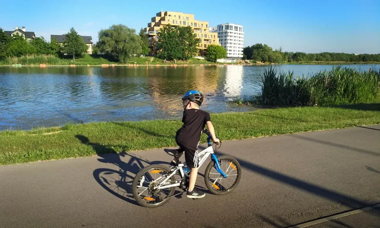 Chłopiec na rowerze odkrywa malownicze trasy rowerowe Rzeszów nad jeziorem.