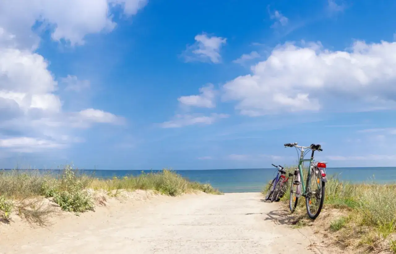 Dwa rowery czekają na ścieżce prowadzącej do morza. Idealne miejsce na przejażdżkę Velo Baltica.
