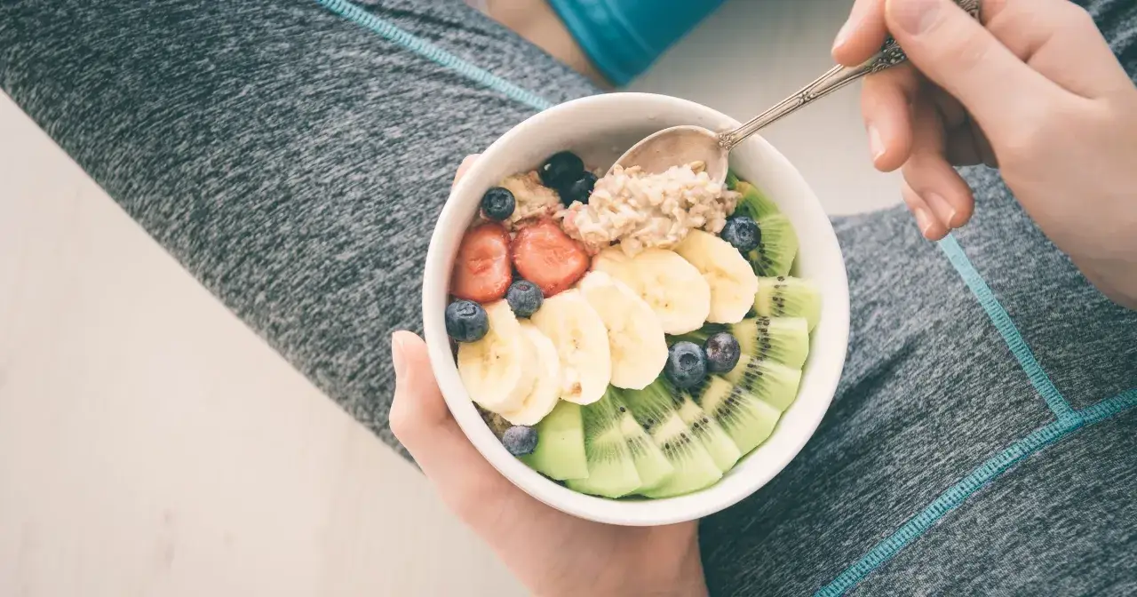 Po treningu warto zjeść owsiankę z owocami: bananem, kiwi, truskawkami i borówkami.
