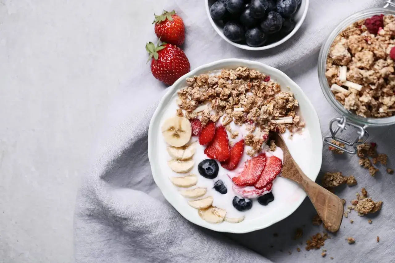 Pyszna granola z jogurtem, bananami, truskawkami i borówkami. Idealne śniadanie, które doda energii na cały dzień.
