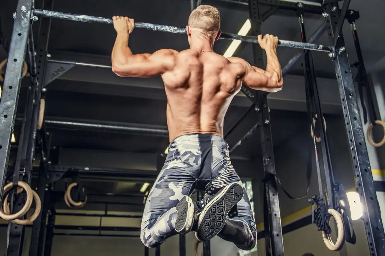Mężczyzna wykonuje podciąganie na drążku. Zastanawiasz się, ile razy w tygodniu ćwiczyć biceps? Taki trening to świetny sposób na budowanie siły.