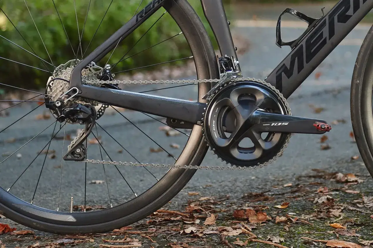 Napęd roweru szosowego z grupami Shimano 105: korba, przerzutka tylna, kaseta i łańcuch.