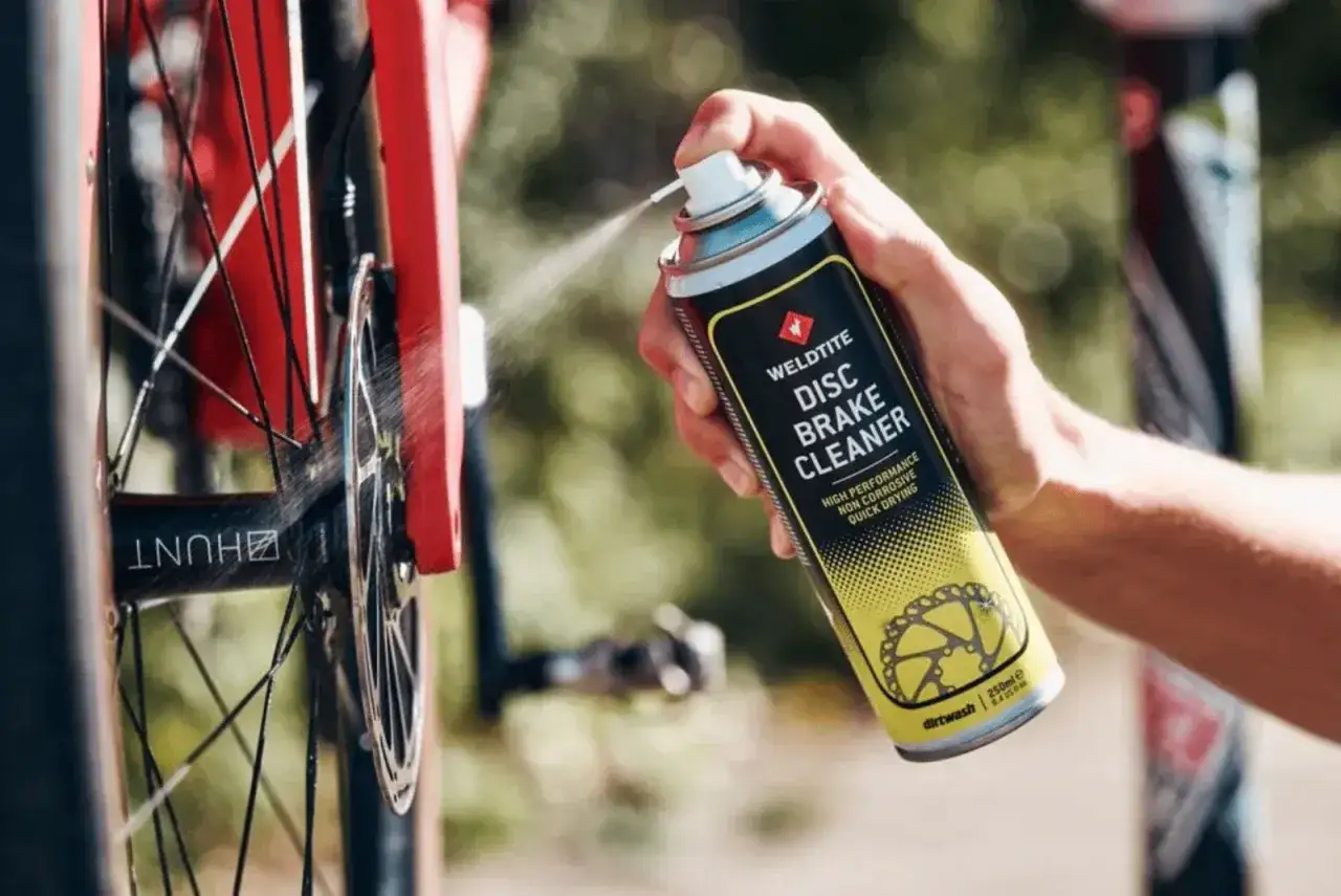 Odtłuszczanie tarcz hamulcowych w rowerze za pomocą sprayu Weldtite Disc Brake Cleaner.