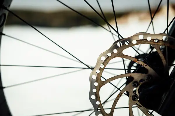 Tarcza hamulcowa roweru z widocznymi szprychami. Zastanawiasz się, czym odtłuścić tarcze hamulcowe w rowerze? Czystość to klucz do skutecznego hamowania.
